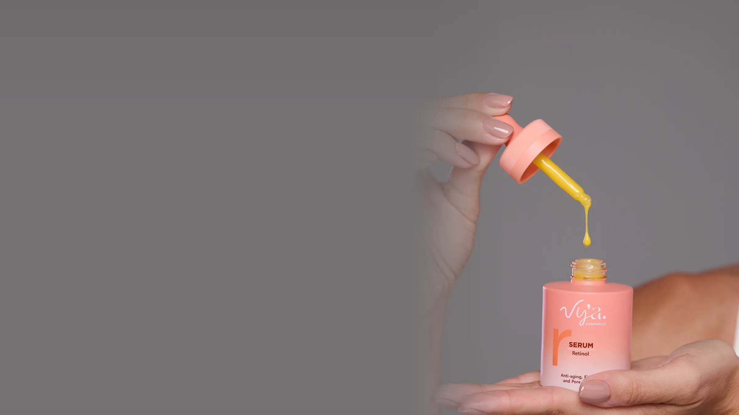Fio amarelo do Sérum Retinol caindo da pipeta no frasco, na palma da mão
